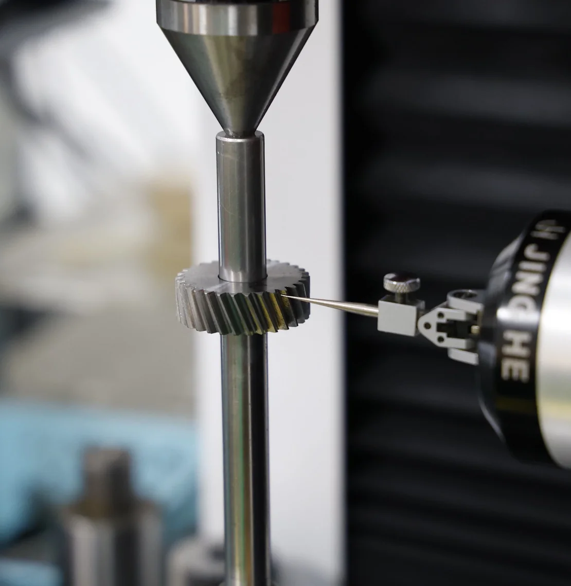 Gear measured against a probe on an inspection machine